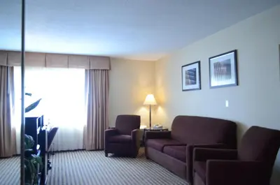 a hotel room with a couch and a chair at Rodeway Inn & Suites East Windsor in East Windsor
