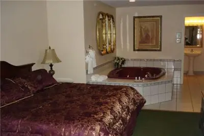 a bedroom with a bed and a bath tub at Colonie Inn and Suites in Latham