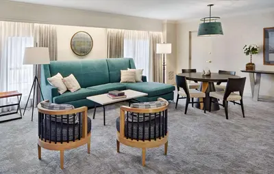 a living room with a green couch and a table at Hilton Pearl River in Pearl River