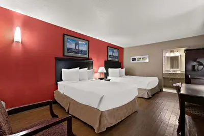 a hotel room with two beds and a red wall at Quality Inn Wayne - Fairfield Area in Wayne