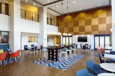 a lobby with tables and chairs and a bar at Hampton Inn by Hilton Garden City Long Island in Garden City