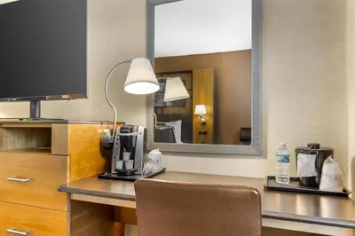 a hotel room with a desk and a mirror at Best Western Queens Gold Coast in Queens