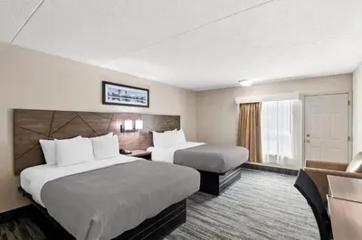a hotel room with two beds and a couch at Quality Inn Westfield - Springfield in Westfield