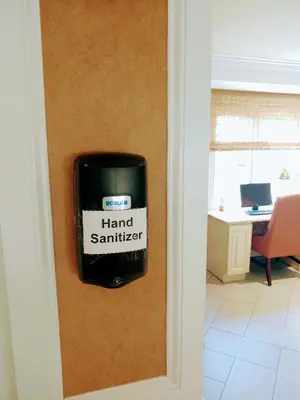 a hand sanitizer dispenser on the wall of a room at The Wilshire Grand Hotel in West Orange