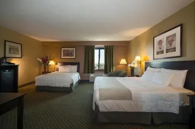 a hotel room with two beds and a chair at Meadowlands Plaza Hotel in Secaucus