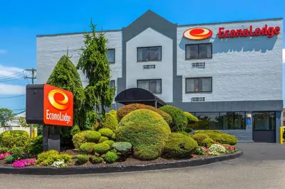 a building with a sign in front of a garden at Econo Lodge Hicksville - Long Island in Hicksville