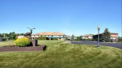 a park with a statue of a deer on the grass at Roosevelt Inn & Suites Saratoga Springs in Saratoga Springs