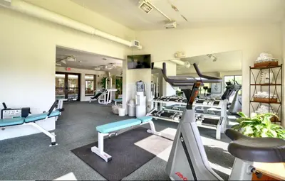 a gym with several tread machines in a room at Roosevelt Inn & Suites Saratoga Springs in Saratoga Springs
