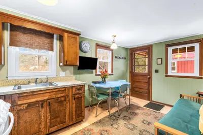 a kitchen with a sink and a table with chairs at Phoenicia Lodge in Phoenicia