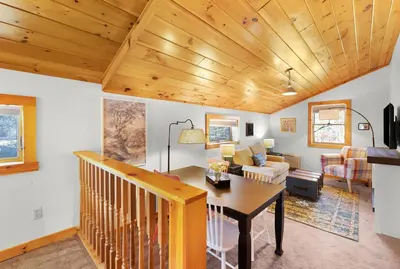 a living room with a wooden ceiling and a table at Phoenicia Lodge in Phoenicia