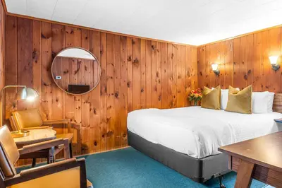 a bedroom with a bed and a table and a mirror at Phoenicia Lodge in Phoenicia