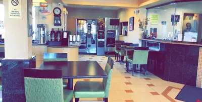 a restaurant with tables and chairs and a bar at Super 8 by Wyndham Hartford in Hartford