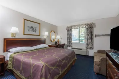 a hotel room with a bed and a flat screen tv at Super 8 by Wyndham Hartford in Hartford