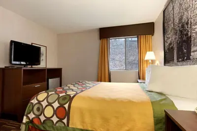 a hotel room with a bed and a flat screen tv at Riverdale Inn in Springfield