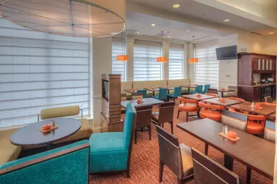 a restaurant with tables and chairs and a cafeteria at Hilton Garden Inn Shelton in Shelton