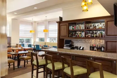 a bar in a restaurant with tables and chairs at Hilton Garden Inn Shelton in Shelton