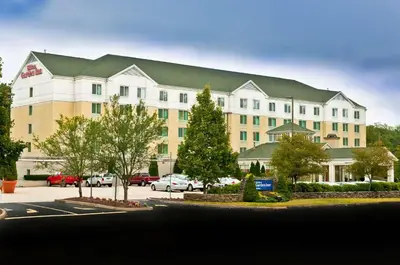 a large white building with a green roof at Hilton Garden Inn Shelton in Shelton