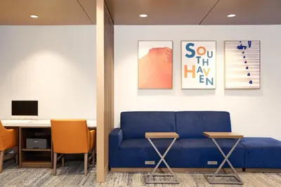 a living room with a blue couch and a desk at Holiday Inn Express & Suites Pittsfield-Lenox-Berkshires by IHG in Pittsfield