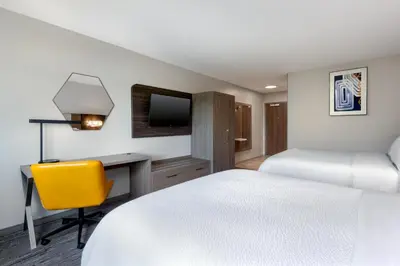 a hotel room with a bed and a desk and a tv at Holiday Inn Express & Suites Pittsfield-Lenox-Berkshires by IHG in Pittsfield