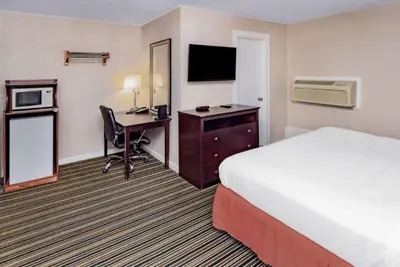 a hotel room with a bed and a desk with a computer at Travelodge by Wyndham Great Barrington Berkshires in Great Barrington