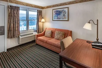 a hotel room with a couch and a table at Travelodge by Wyndham Great Barrington Berkshires in Great Barrington