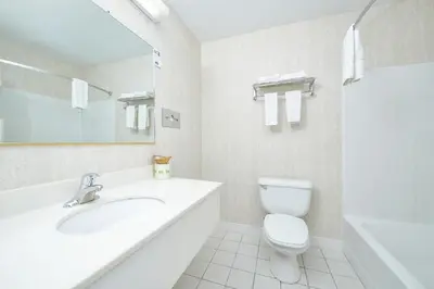 a white bathroom with a sink and a toilet at Travelodge by Wyndham Great Barrington Berkshires in Great Barrington