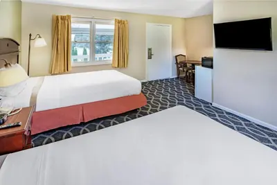 a hotel room with a bed and a flat screen tv at Travelodge by Wyndham Great Barrington Berkshires in Great Barrington