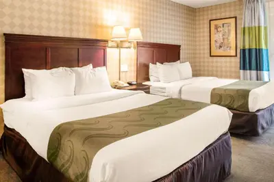 a hotel room with two beds with white sheets at Quality Inn West Springfield in West Springfield