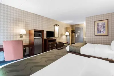 a hotel room with two beds and a desk at Quality Inn West Springfield in West Springfield