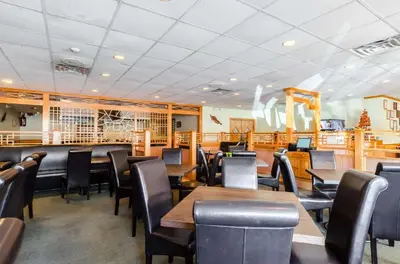 a restaurant with wooden tables and black chairs at Quality Inn West Springfield in West Springfield