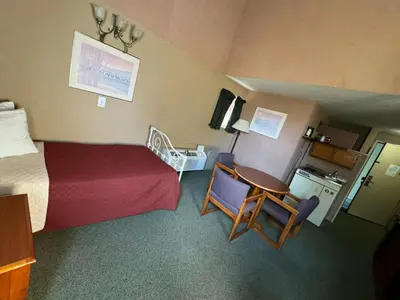a hotel room with a bed and a table and chairs at FairBridge Inn and Suites West Point in Highland Falls