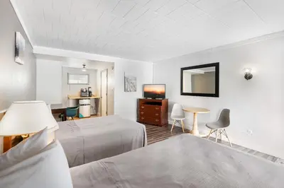 a bedroom with a bed and a table and a tv at FairBridge Inn and Suites West Point in Highland Falls