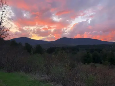 a sunset in the mountains with trees and mountains at Romantic, Magical Cottage in Catskills nr Woodstock in Willow