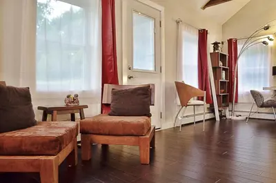 a living room with a couch and a chair and windows at Romantic, Magical Cottage in Catskills nr Woodstock in Willow