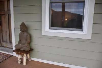 a statue sitting on a porch next to a window at Romantic, Magical Cottage in Catskills nr Woodstock in Willow