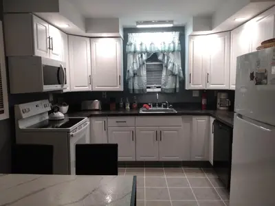 a kitchen with white cabinets and a sink at Mountain Retreat in Wilmington