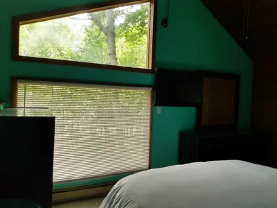 a bedroom with a green wall and a window at Mountain Retreat in Wilmington