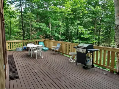 a grill on a deck with a table and chairs at Mountain Retreat in Wilmington