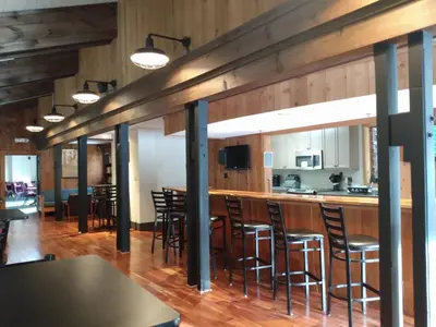 a bar in a restaurant with wooden walls and stools at Mountain Retreat in Wilmington