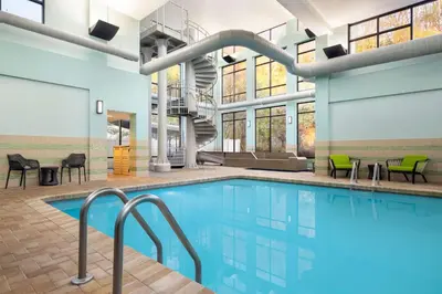 a swimming pool with chairs and a staircase in a building at Hampton by Hilton Shelton in Shelton