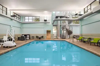 a large swimming pool in a building with a staircase at Hampton by Hilton Shelton in Shelton