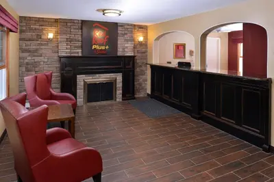 a bar in a hotel room with a fireplace at Red Roof Inn PLUS+ & Suites Guilford in Guilford