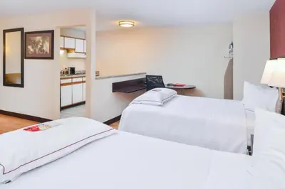 a hotel room with two beds and a kitchen at Red Roof Inn PLUS+ & Suites Guilford in Guilford