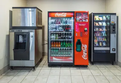 a cocacola soda machine and a drink cooler in a store at Red Roof Inn PLUS+ South Deerfield - Amherst in South Deerfield