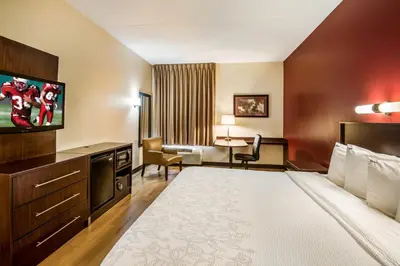 a hotel room with a large bed and a television at Red Roof Inn PLUS+ South Deerfield - Amherst in South Deerfield