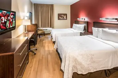 a hotel room with two beds and a flat screen tv at Red Roof Inn PLUS+ South Deerfield - Amherst in South Deerfield