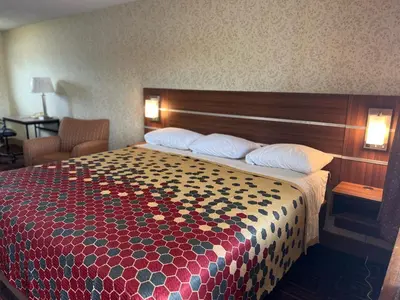 a hotel room with a bed with a colorful bedspread at American Inn in Branford