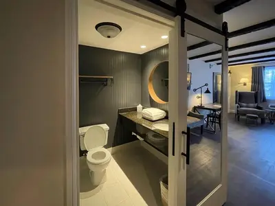 a bathroom with a toilet and a sink at The Century House Latham - North Albany, an Ascend Collection Hotel in Latham