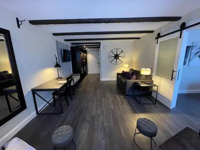 a living room with a couch and a table and chairs at The Century House Latham - North Albany, an Ascend Collection Hotel in Latham