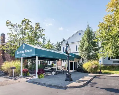 a building with a clock in front of it at The Century House Latham - North Albany, an Ascend Collection Hotel in Latham